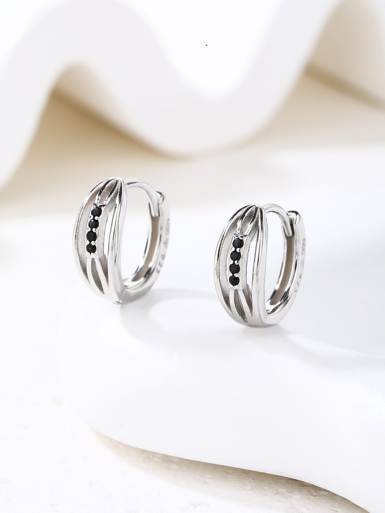 Black stone-studded hoop earrings with a band design and a textured pattern 4